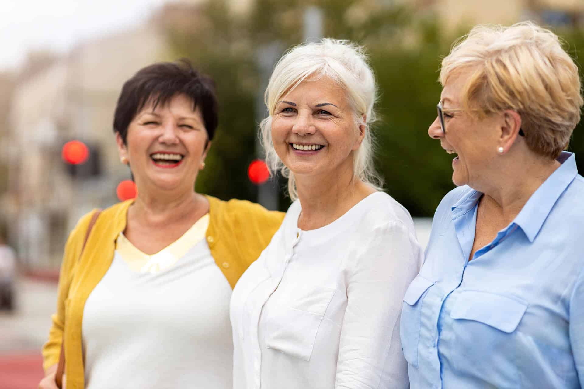 Lady in white with denture implants in Charlotte NC